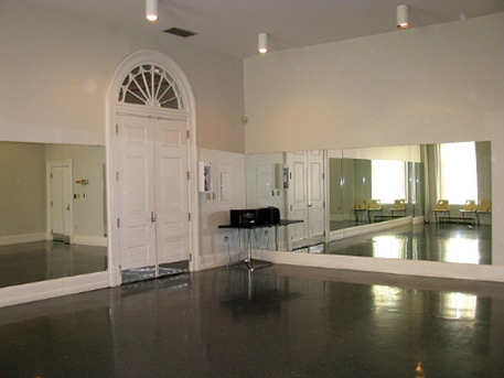 corner of a room with double doors and mirrors on two walls