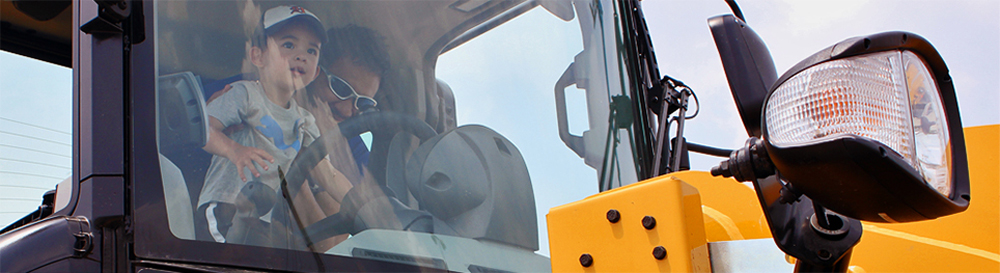 Man and child behind the wheel of a vehicle