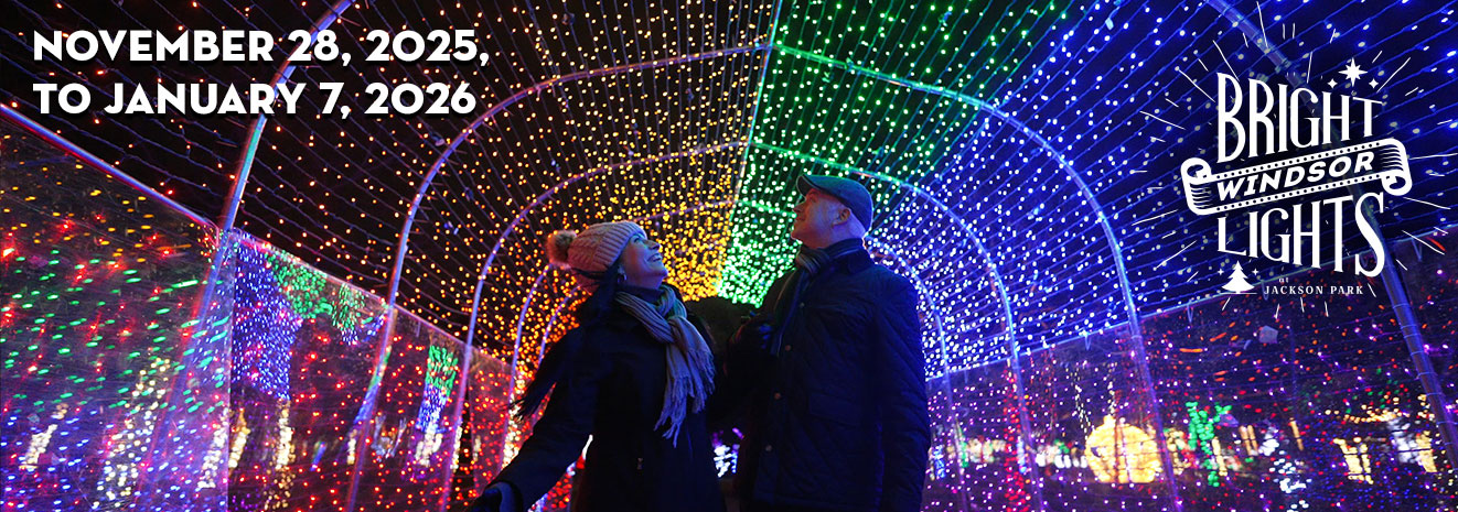 Couple smiling and admiring a light tunnel, logo for Bright Lights Windsor at Jackson Park, and dates November 28, 2025, to January 7, 2026