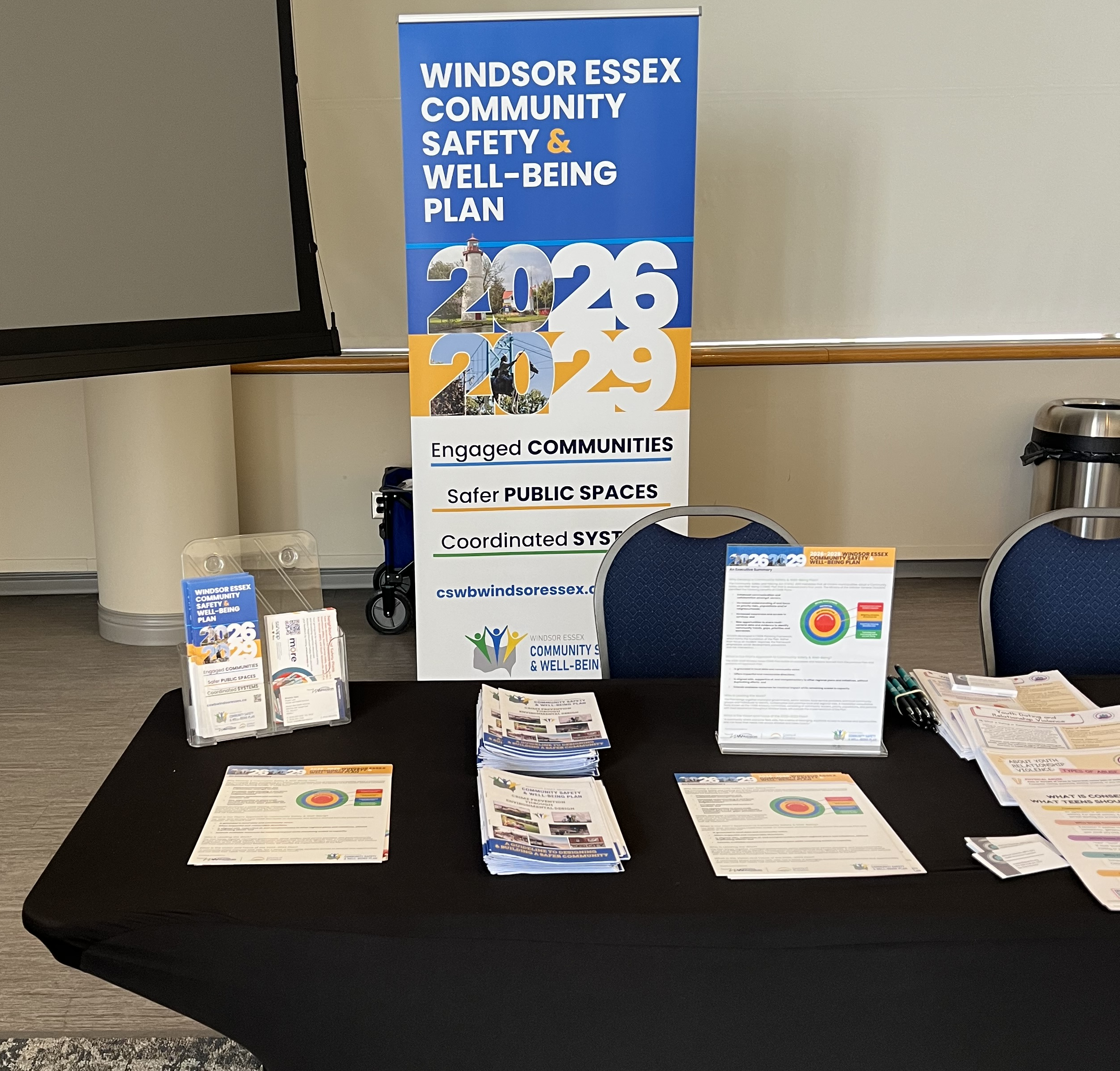 Information booth displaying Windsor Essex Community Safety & Well-Being Plan banner and resources