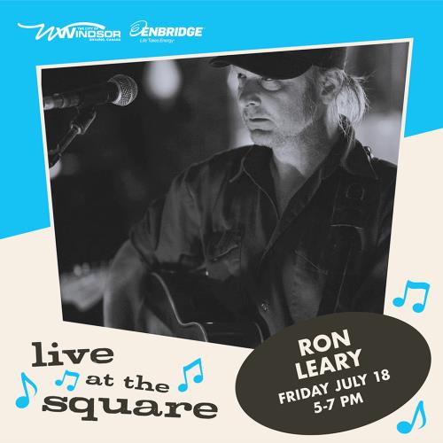 Ron Leary with an acoustic guitar at a microphone